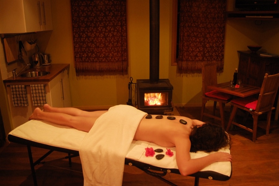 Therapist performing a back massage on a draped client